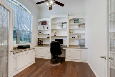 The study/home office with built-in desk, shelves and storage along with high ceiling, rich wood flooring and crown molding makes working from home easier.   The detailed glass double doors offer privacy and the windows fill the room with natural light.