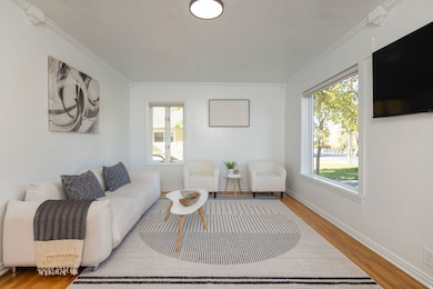 Living area with wood finished floors and crown molding