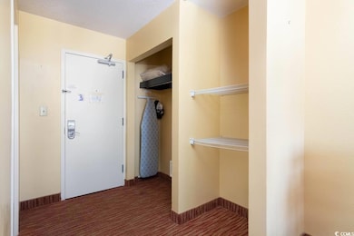 Interior space with dark carpet and a textured cei