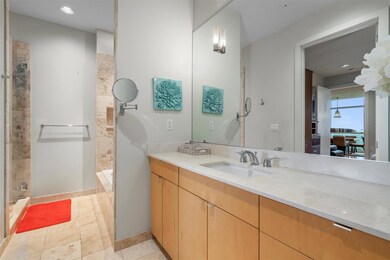 Bathroom featuring tiled shower, vanity, and rece