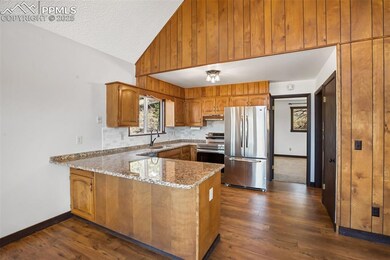 Kitchen with light stone counters, a sink, brown c