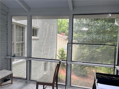 Sunroom with beam ceiling and a balcony