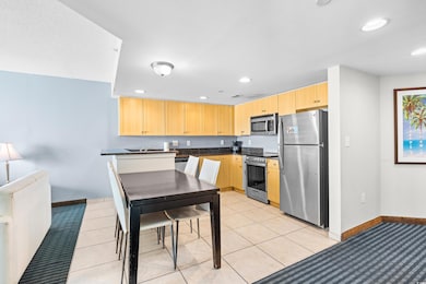 Kitchen with light brown cabinetry, recessed light