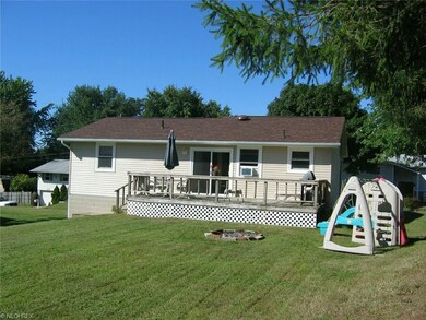 Back of house with deck and playground equipment