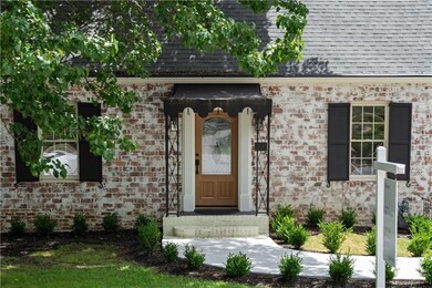 Property entrance with a shingled roof and brick siding