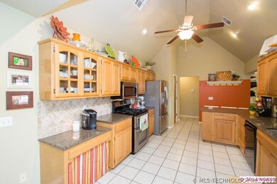 Kitchen with granite tumbled marble, vaulted ceili