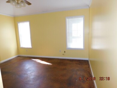 MASTER BED ROOM WITH SLOP CEILING WITH FAN, STAINED CONCRETE FLOOR