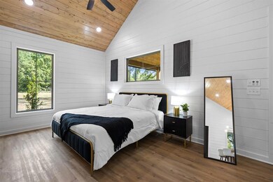 Bedroom featuring hardwood / wood-style flooring, vaulted ceiling, wooden ceiling, and ceiling fan