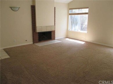 Sunny living room with vaulted ceiling and firepla
