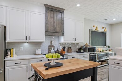 Kitchen with a textured ceiling, light wood-type f
