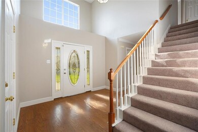 Two story foyer with laminate flooring through foy