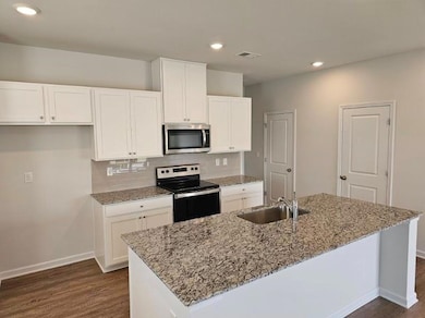 Kitchen featuring visible vents, white cabinets, e