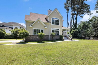 Traditional home with a front yard, a chimney, roof with shingles, brick siding, and a porch