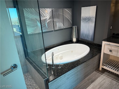 Bathroom featuring a tile shower, a jetted tub, an