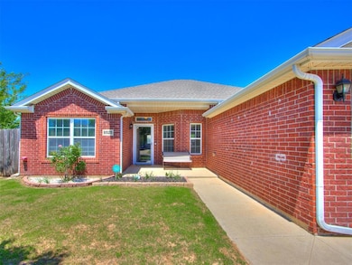 Doorway to property with brick siding, a yard, and roof with shingles