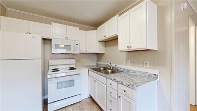Kitchen with white appliances, a sink, white cabin