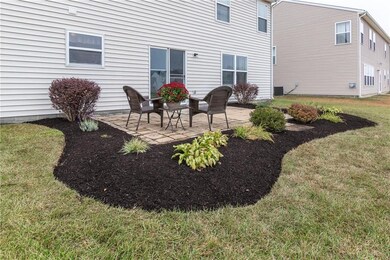 Beautiful landscaping surrounds paver patio. 