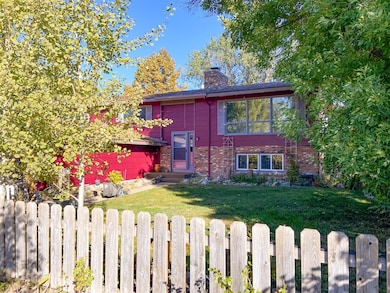 Split foyer home featuring a chimney, brick siding, and entry steps