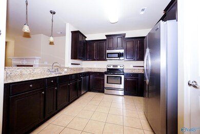 Stainless appliances, Espresso wood cabinetry and beautiful granite countertops. Home has new oversized water heater. Kitchen has bar and is open to dining room, living area and covered back porch overlooking huge yard with fruit trees.