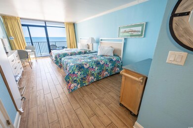 Bedroom with expansive windows, access to exterior, light wood-style flooring, crown molding, and a water view