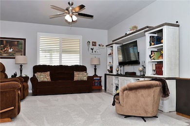 Living room featuring ceiling fan and light colore