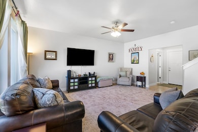 Living area with ceiling fan and wood finished floors