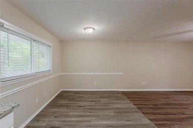 Unfurnished room with a textured ceiling, and baseboards
