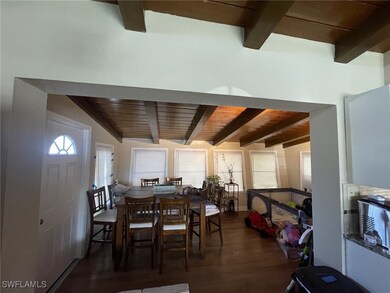 Dining area with dark wood finished floors, beamed