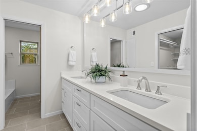 Full bathroom with double vanity, tile patterned 