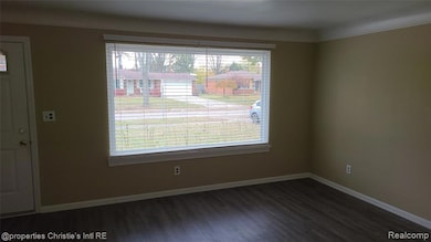 Unfurnished dining area featuring dark wood-type flooring and crown molding