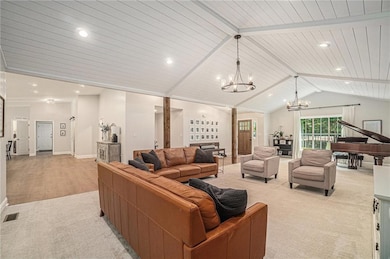 Living room featuring a chandelier, light colored carpet, wood ceiling, recessed lighting, and baseboards