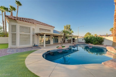 Rear view of house with a fenced backyard, a patio, solar panels, stucco siding, and a tiled roof