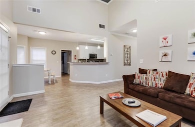 Living area with a towering ceiling, visible vents