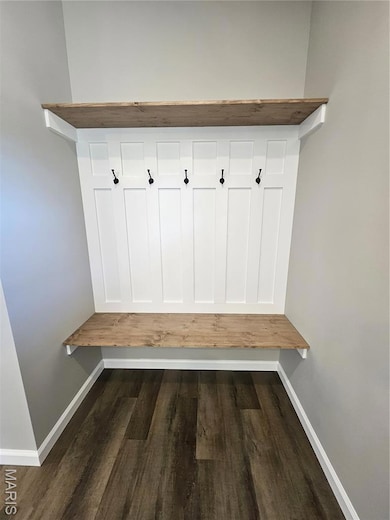 Mudroom featuring dark wood-type flooring and baseboards