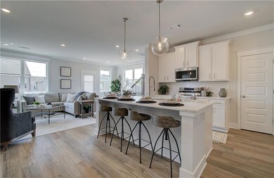 Kitchen featuring white cabinetry, light hardwood 
