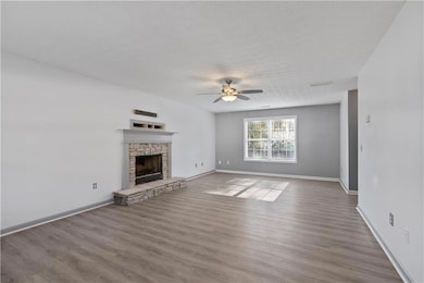 Unfurnished living room with ceiling fan, a firepl
