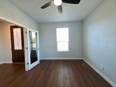 Unfurnished room featuring dark wood-style floori