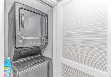 Washroom with a textured ceiling, laundry area, an