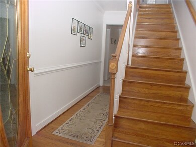 Foyer has hardwood floors and stairs, crown moldin