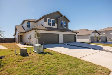 View of front of house with board and batten siding, concrete driveway, an attached garage, and roof with shingles