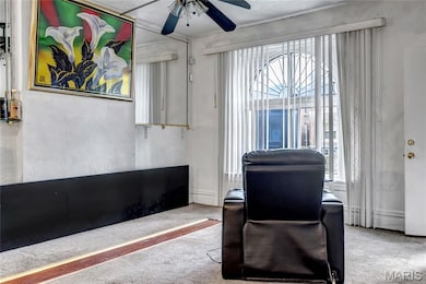 Carpeted office with a ceiling fan and plenty of natural light