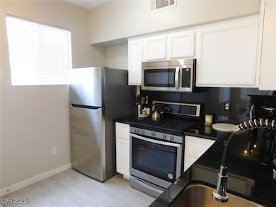 Kitchen with stainless steel appliances, white cab