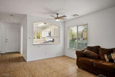 Living room featuring a ceiling fan, light tile pa