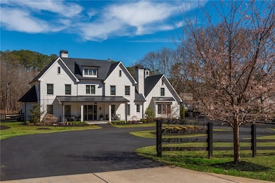 Modern 4-sided brick farmhouse set on 3 acres in the heart of Milton, Georgia with a paved circular driveway is a luxurious outdoor retreat!