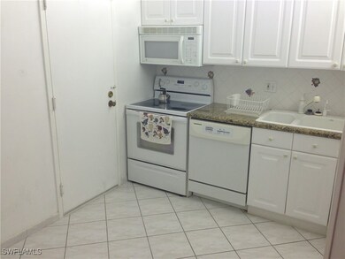 Kitchen featuring white appliances, a sink, white