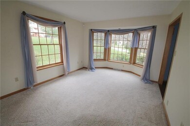 The living room has a neutral decor and bay window