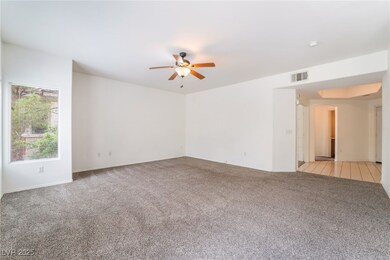 Empty room with light carpet, a ceiling fan, arche