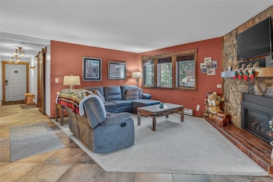 Living area featuring a stone fireplace and stone finish flooring