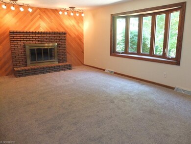 Family room with brick fireplace and bay window.