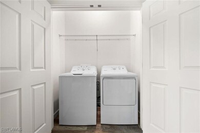Laundry room with dark hardwood / wood-style flooring and independent washer and dryer